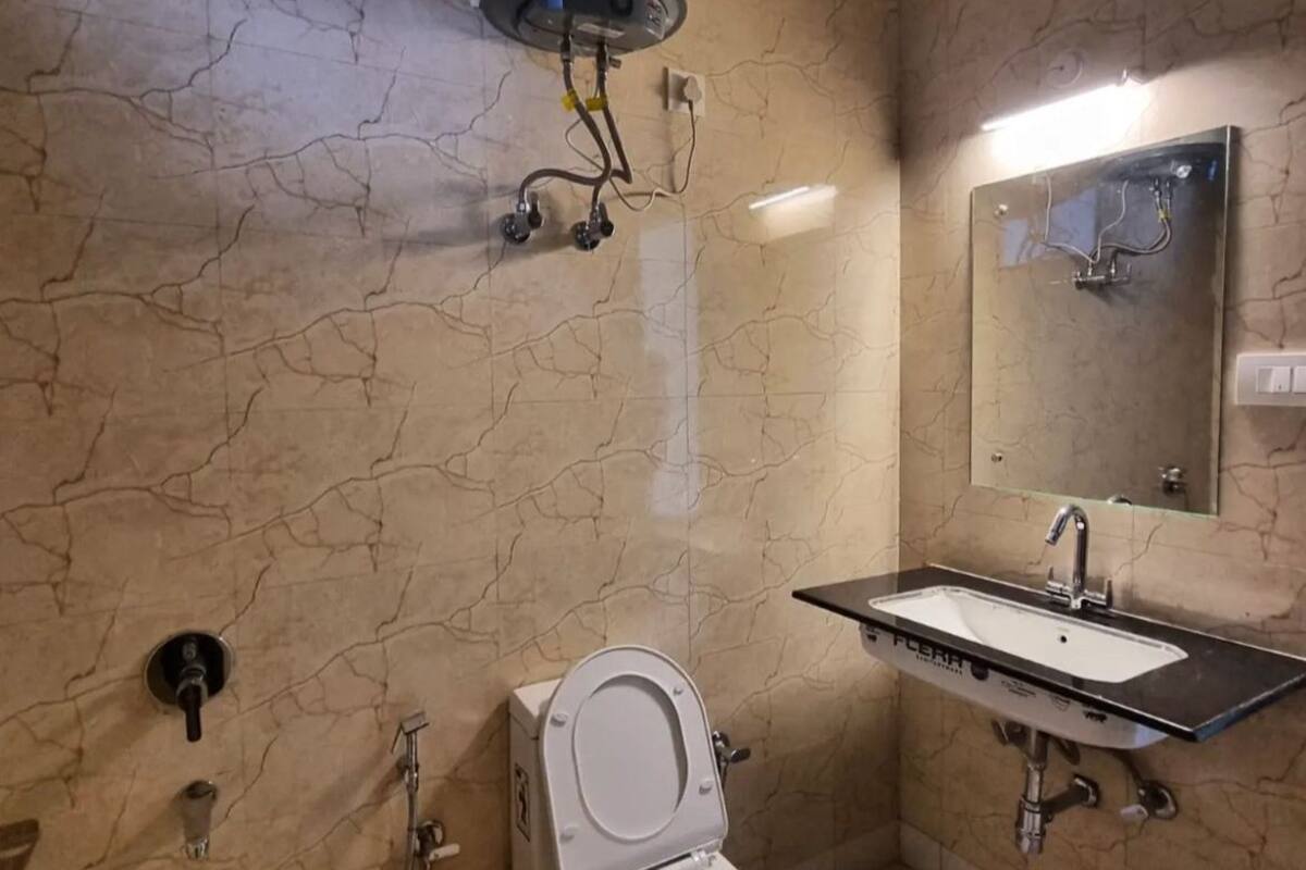 A bathroom with a toilet, a sink, and a mirror.
