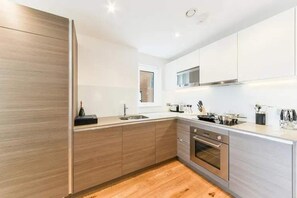 Apartamento | Cocina privada | Frigorífico, microondas, horno y placa de cocina