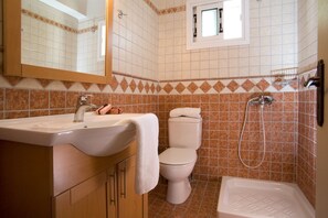Villa | Badkamer | Een douche, een haardroger, handdoeken