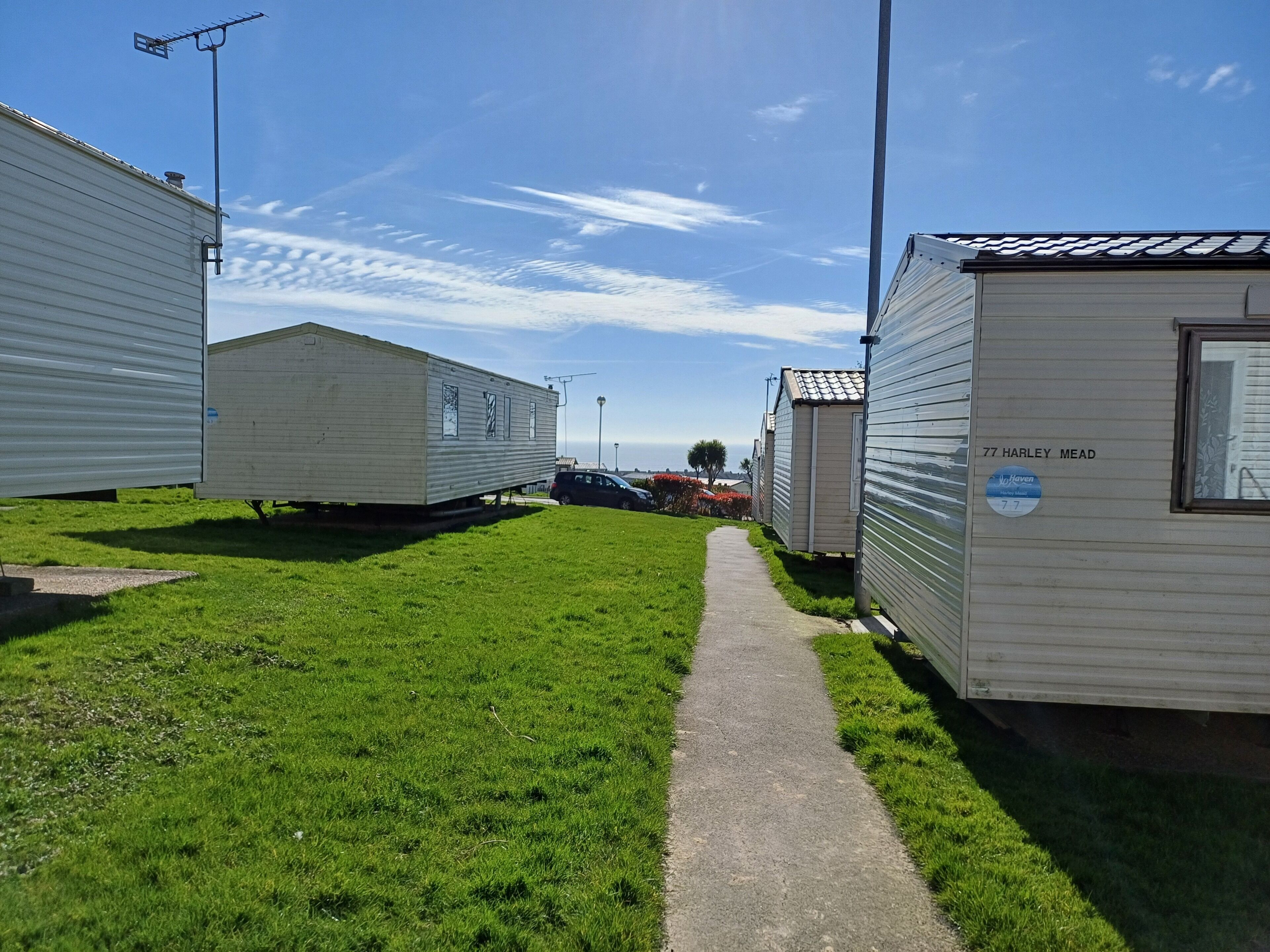 A row of mobile homes with a paved walkway between them.