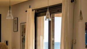 Cozinha moderna com vista para o mar, uma pia e luminárias pendentes.