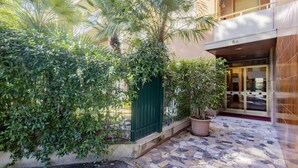 A hotel entrance with a tiled patio, a green gate, and potted plants. - La Pineta sul Mare by Wonderful Italy (Sanremo)
