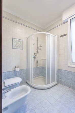 Un baño con cabina de ducha, inodoro y bidé.