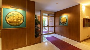 A hallway with wooden paneling, a red carpet, and two framed artworks on the walls. - La Pineta sul Mare by Wonderful Italy (Sanremo)