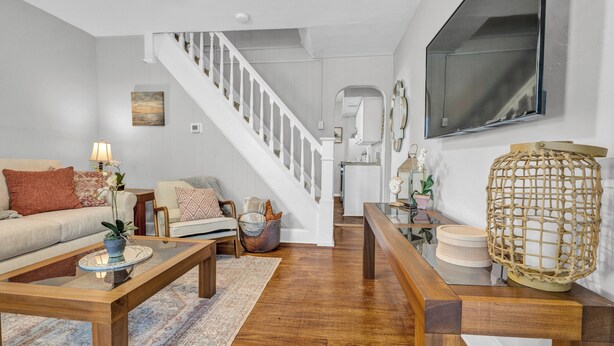 Un salon moderne avec une table basse en bois, un canapé et un escalier menant à la cuisine.