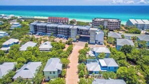 A resort with multiple buildings, a central pathway, and a view of the ocean.