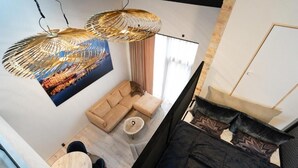 Ένα μοντέρνο σαλόνι με έναν καναπέ, ένα στρογγυλό τραπεζάκι σαλονιού και ένα φωτιστικό οροφής.