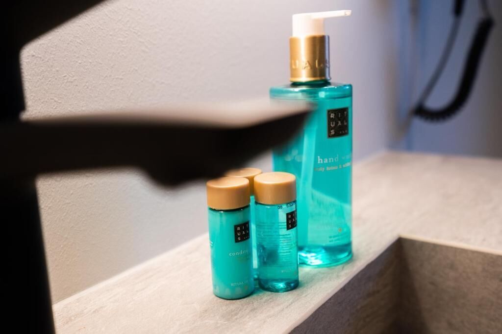 Ein Badezimmerschrank mit drei Flaschen Handdesinfektionsmittel und einer größeren Flasche Handseife.