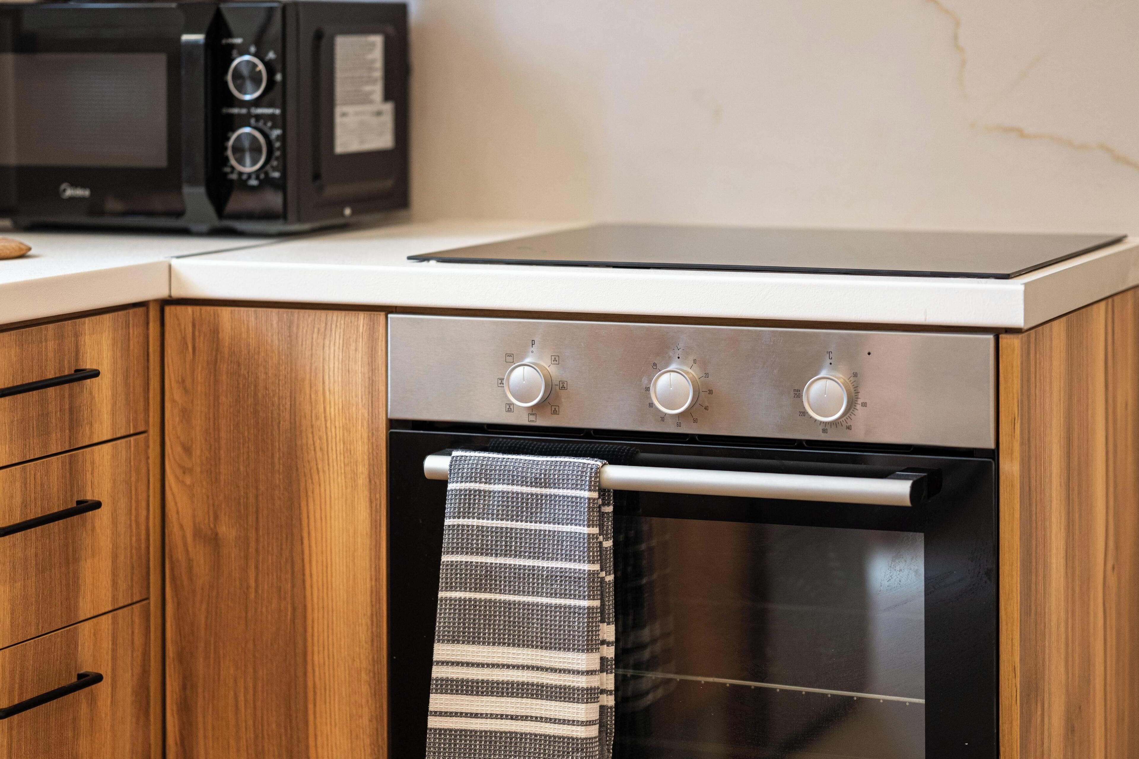 A kitchen with a microwave, an oven, and a stovetop.
