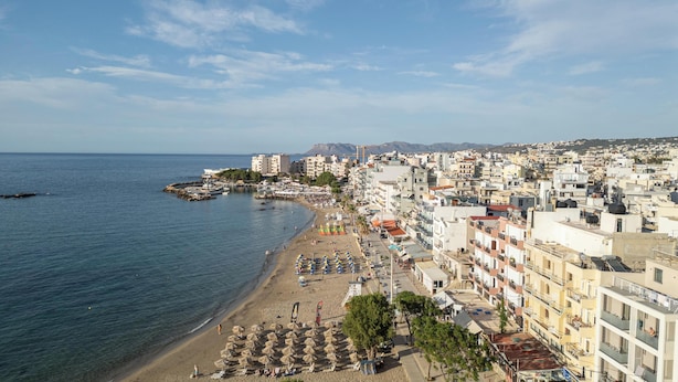 A coastal cityscape with a beach, buildings, and a clear sky. - Niman Beachside Apartments (Chania)