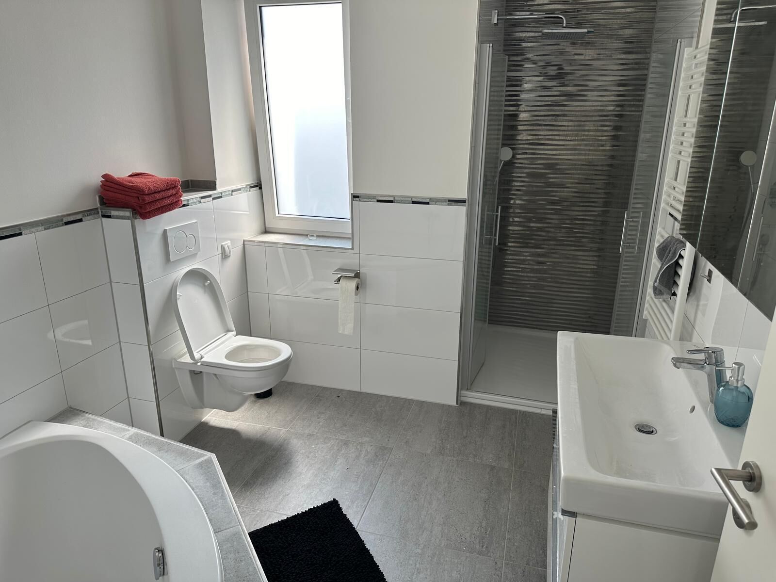 Un baño moderno con inodoro, lavabo y ducha.