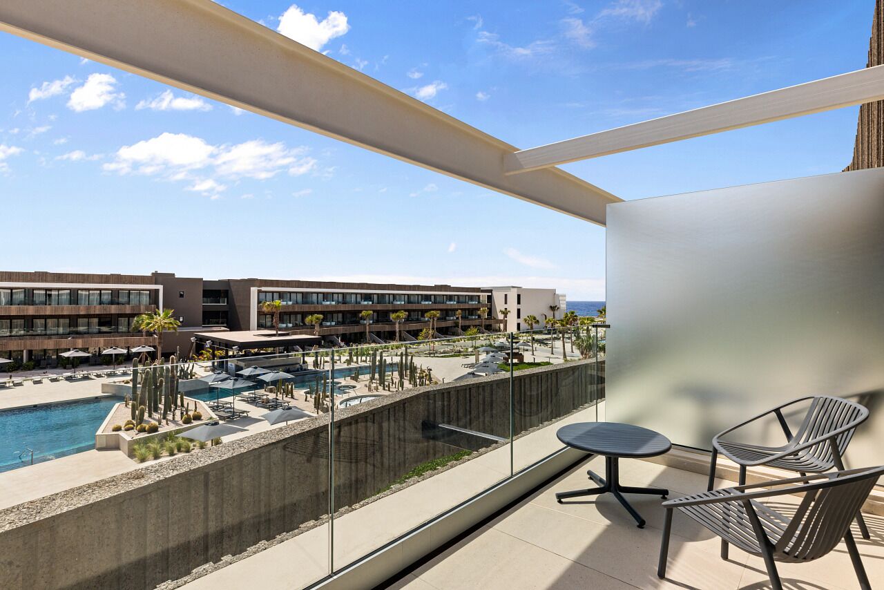 Ein Balkon mit Blick auf einen Pool und die Hotelgebäude.
