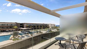 Ein Balkon mit Blick auf einen Pool und die Hotelgebäude.