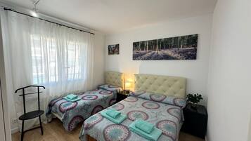 1 dormitorio, tabla de planchar con plancha, ropa de cama