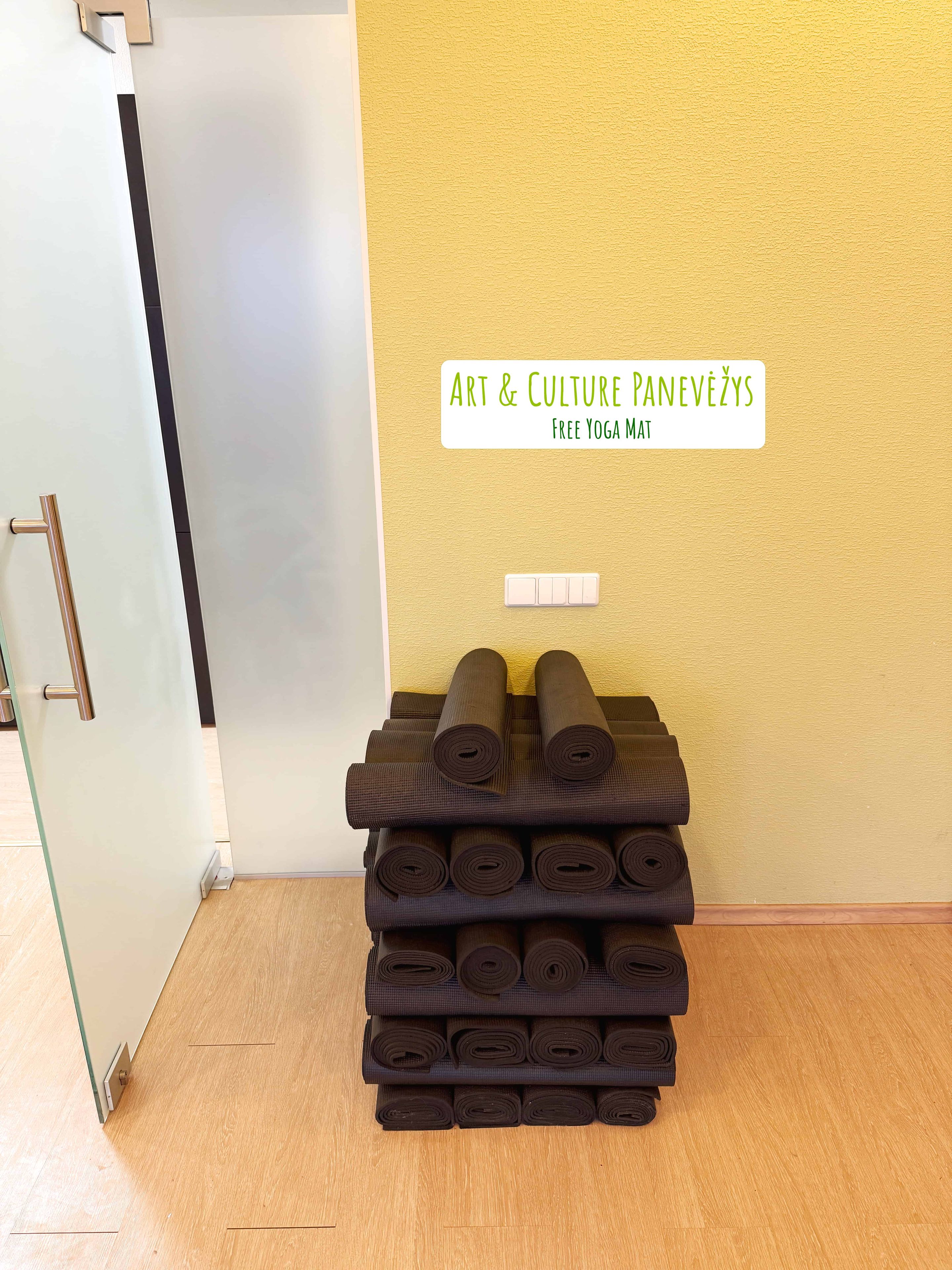 Un conjunto de esterillas de yoga en una habitación con pared amarilla y una puerta.