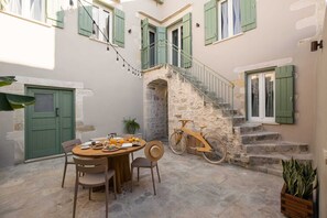 Enjoy a meal in the serene courtyard, surrounded by lush greenery and a vintage charm.