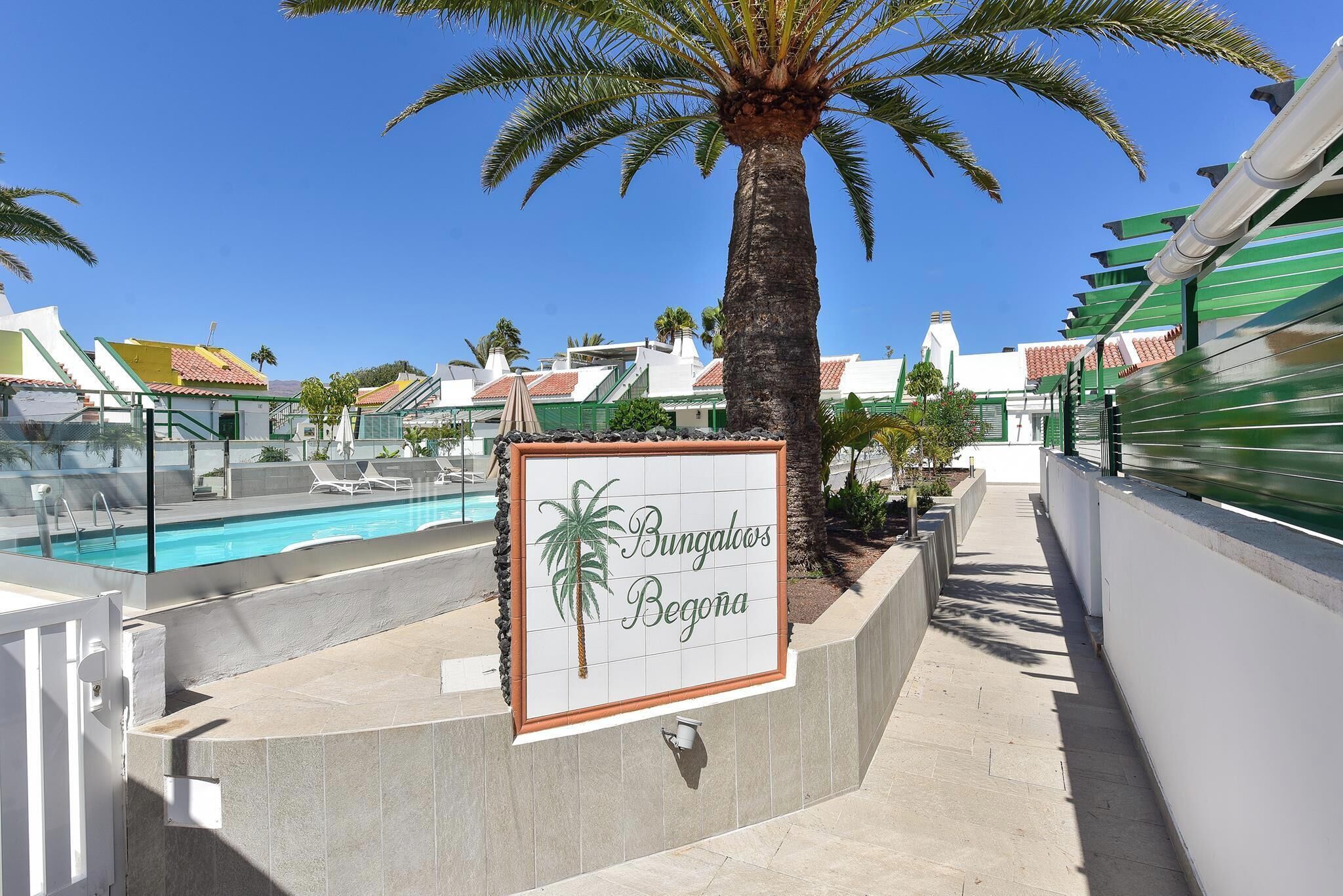 Señalización de 'Bunagaoos Begona' con piscina y palmeras.