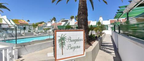 Señalización de 'Bunagaoos Begona' con piscina y palmeras.