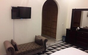 Relax in a cozy space with a comfortable bed, sofa, and flat-screen TV.
