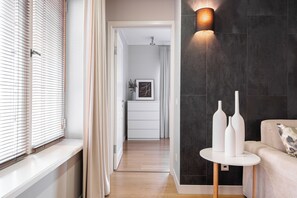 Un intérieur moderne avec un plancher en bois, un canapé blanc et une table ronde agrémentée de vases.