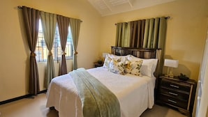 Une chambre à coucher avec un lit, des rideaux, une table de chevet et une commode.