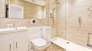 A modern bathroom with a toilet, sink, and shower.
