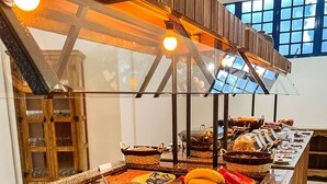 Un buffet proposant une variété de plats et de boissons, notamment une grande carafe de jus d’orange et un bol de soupe.