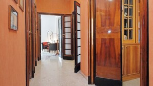 Un pasillo con puertas de madera y un comedor al fondo.