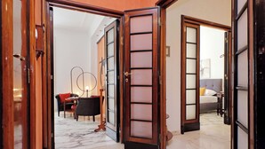 Un vestíbulo de hotel con piso de mármol, un sofá, una mesa y una cama al fondo.