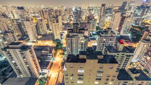 A high-rise urban area with multiple buildings, streets, and illuminated areas.