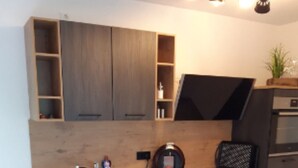 A modern kitchen with a built-in oven, a sink, and a coffee machine. - Apartment Wurmbergblick (Braunlage)