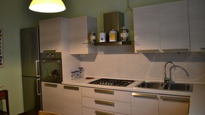 A kitchen with white cabinets, a stainless steel refrigerator, a gas stove, and a sink. - Le bouganville, 3 bedrooms Apt, city center and parking place (Desenzano del Garda)