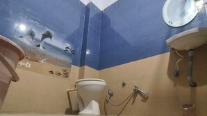 A bathroom with a toilet, sink, and mirror. - Hotel divine and restaurant (Pratapgarh)