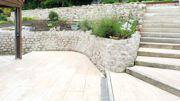 A stone retaining wall with a curved design, a metal handrail, and a set of stairs leading up to a building. - Le Charme Des Cerisiers - 3-star family B&B with private spa and garden.  (Bouvigny-Boyeffles)