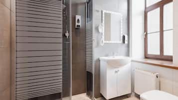 Een douche, handdoeken, zeep, toiletpapier