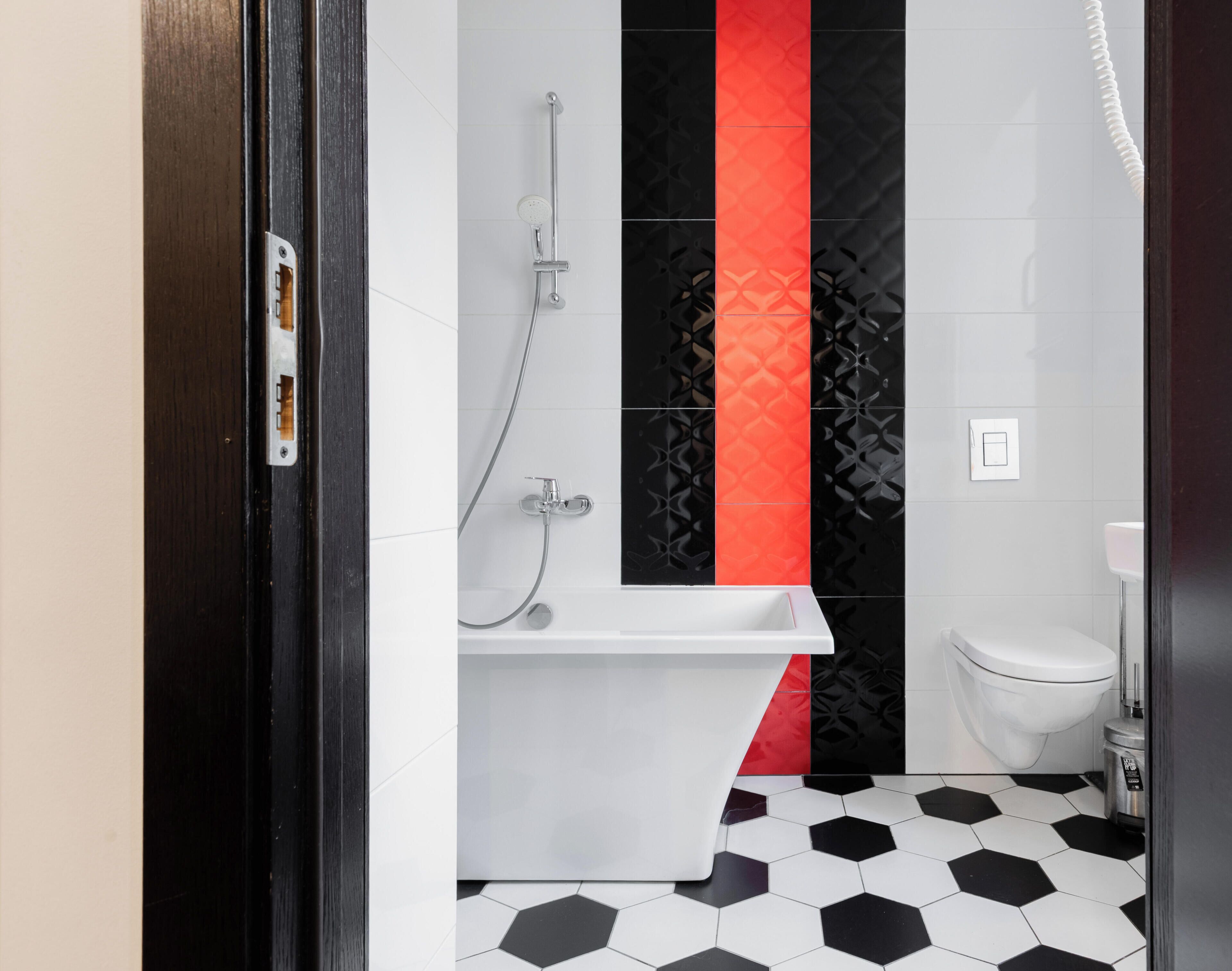 Baño con bañera blanca, inodoro y ducha.