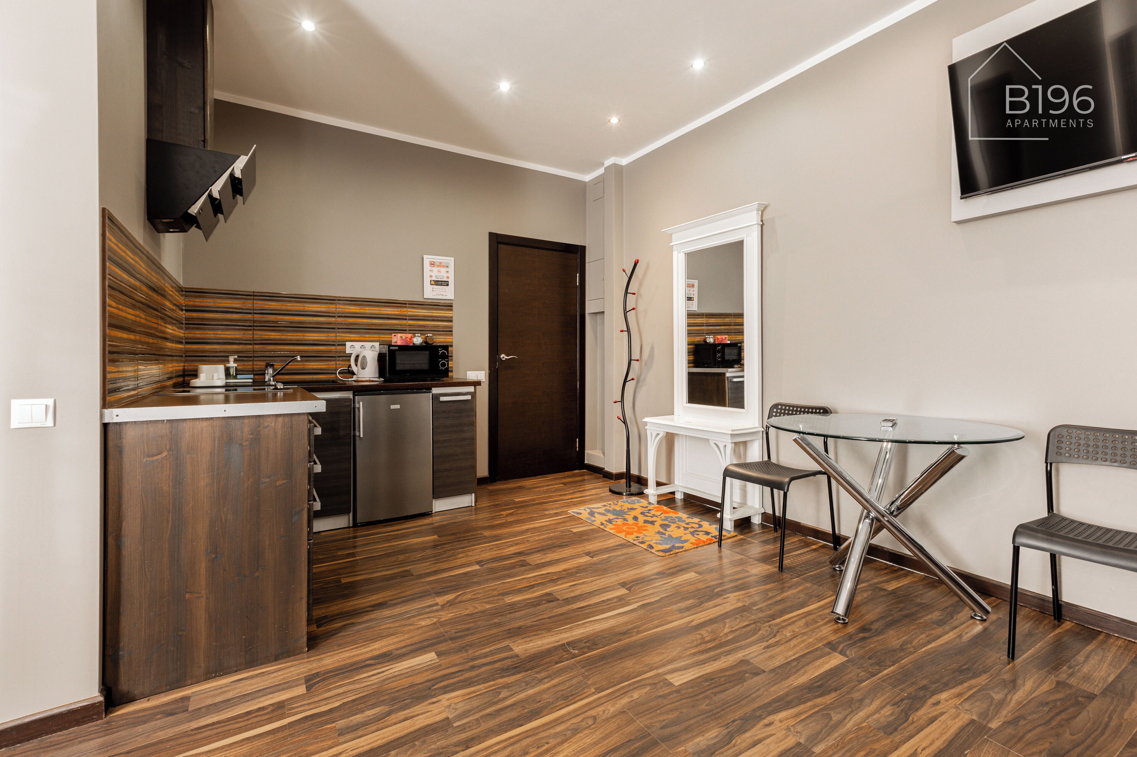 A modern kitchen with a dishwasher, microwave, and a wooden cabinet.