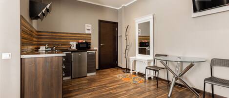 A modern kitchen with a dishwasher, microwave, and a wooden cabinet.