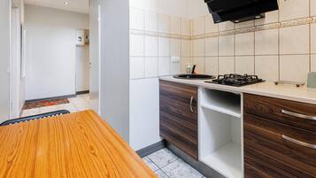 A kitchen with a wooden table, a gas stove, and a microwave.