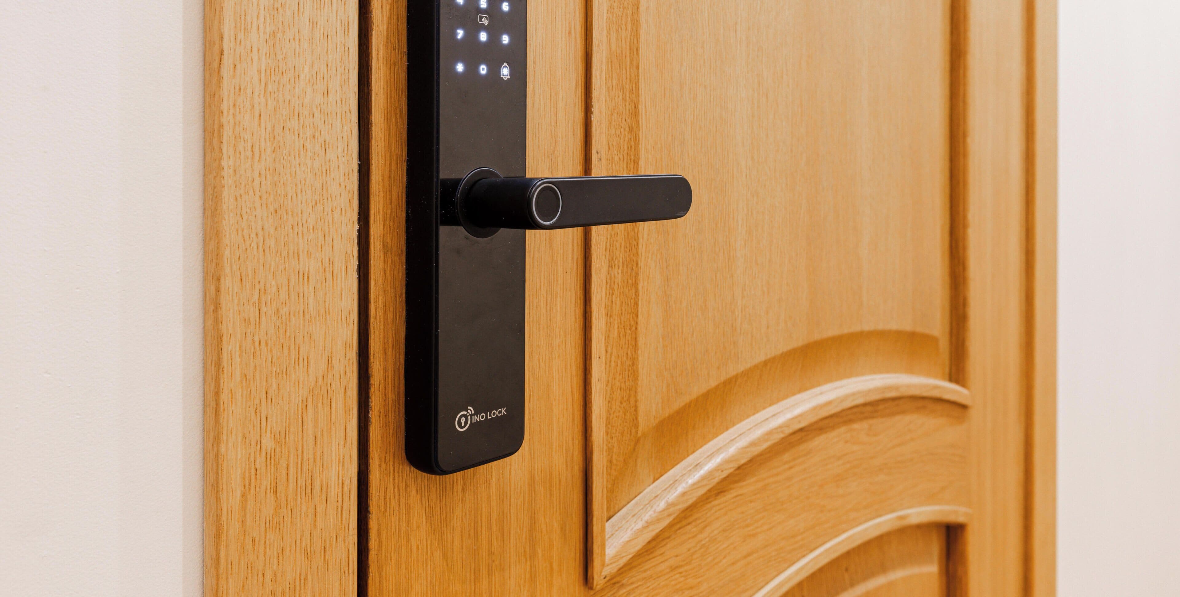 Une serrure électronique moderne sur une porte en bois.