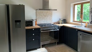 A modern kitchen with a stainless steel refrigerator, a built-in oven, a microwave, and a dishwasher. - Les Sechoirs - Gite La Riviera (Clairac)
