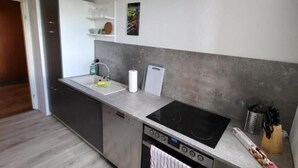 Eine moderne Küche mit Einbauofen, Kochfeld und Spüle.