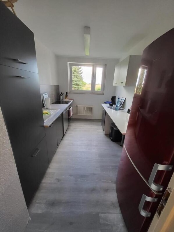 A compact kitchen with a window, a refrigerator, and a sink.