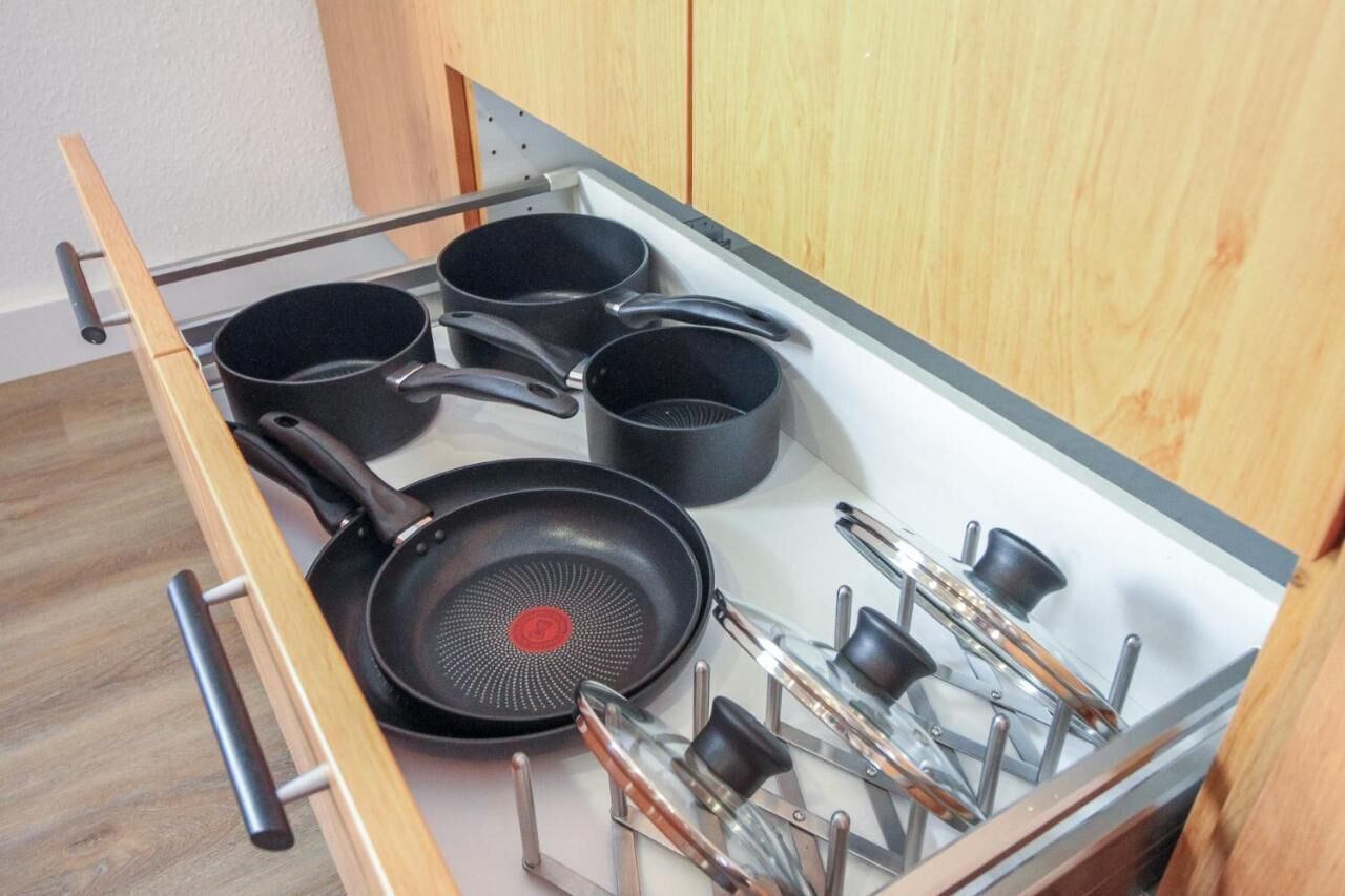 A kitchen drawer with pots and pans.