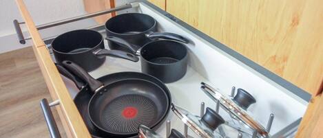 A kitchen drawer with pots and pans.