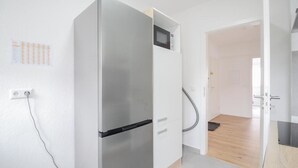 Eine moderne Küche mit integriertem Kühlschrank, Mikrowelle und Holzboden.