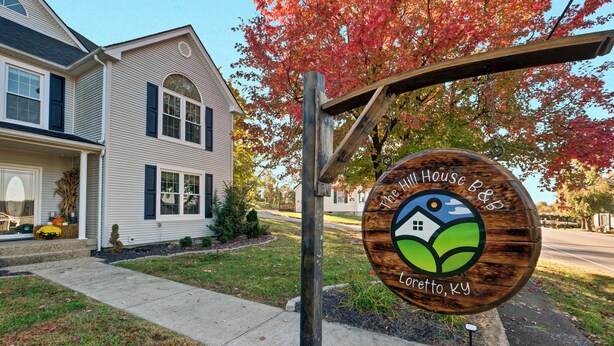 A wooden sign with a house and leaf design, indicating a house with a garden in Letto, KY.