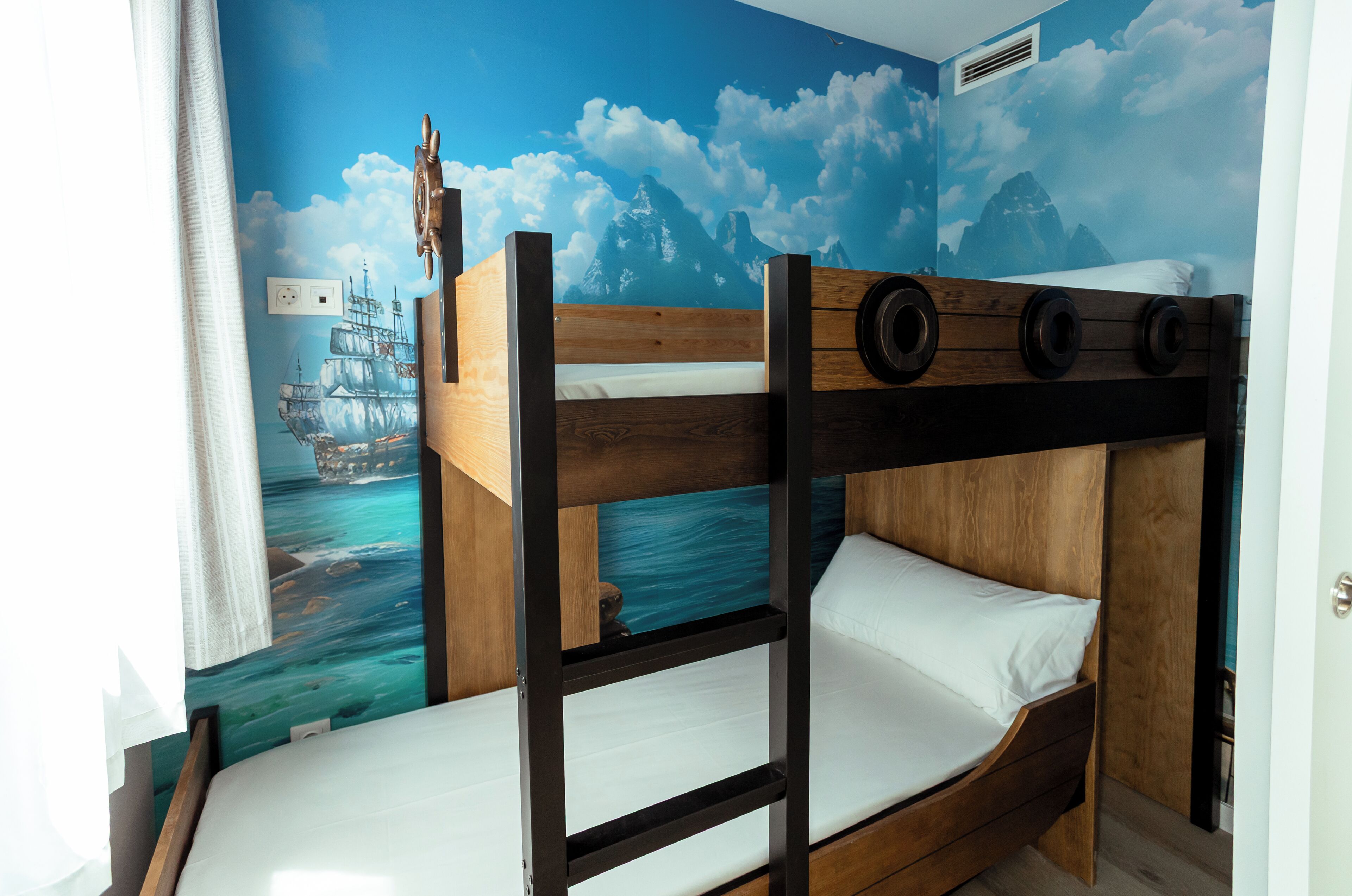 Camera con letto a castello e un murale raffigurante una nave.