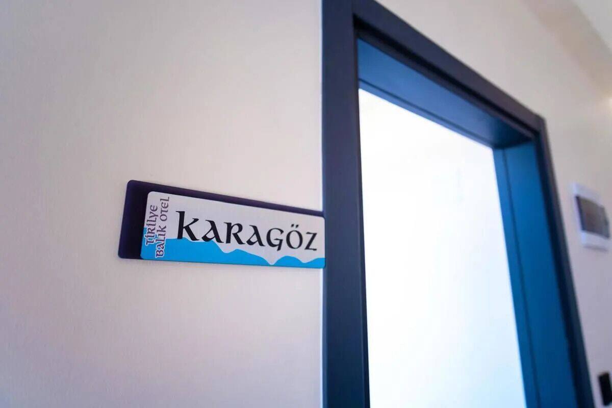 Un letrero en una pared con el nombre "KARAGÖZ" y el texto "TRITHELYE HOTEL OYEL".