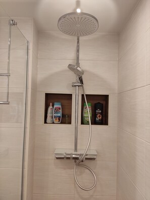 A shower with a handheld showerhead and a handheld shower attachment.